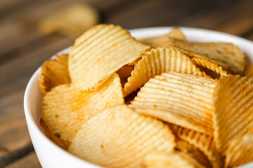 Potatoes chips in bowl good for snack for beer or ale on a natural wooden table. Good for beer...