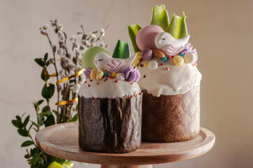 Easter cake with raisins and white fondant with birds and macaroons. on a light background with...