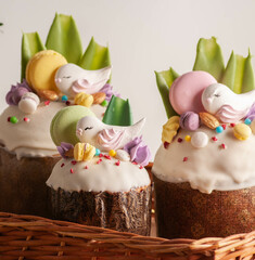 Easter cake with raisins and white fondant with birds and macaroons. on a light background with...