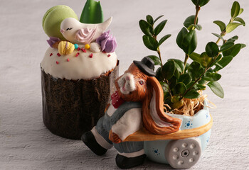 Easter cake with raisins and white fondant with birds and macaroons. on a light background with rabbits and flowers