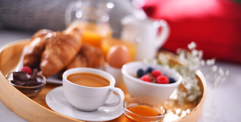 A tray with breakfast on a bed in a hotel room