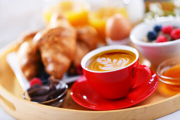 A tray with breakfast on a bed in a hotel room