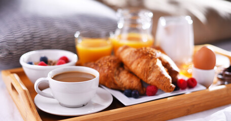 A tray with breakfast on a bed in a hotel room