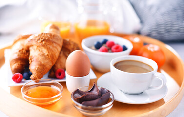 A tray with breakfast on a bed in a hotel room
