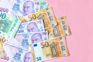 Group of money EURO and Turkish Lira banknote arranged in a chaotic manner. EURO and Turkish banknote isolated on pink background. Exchange money, Cash, Travel concept, Money background ,Currency.