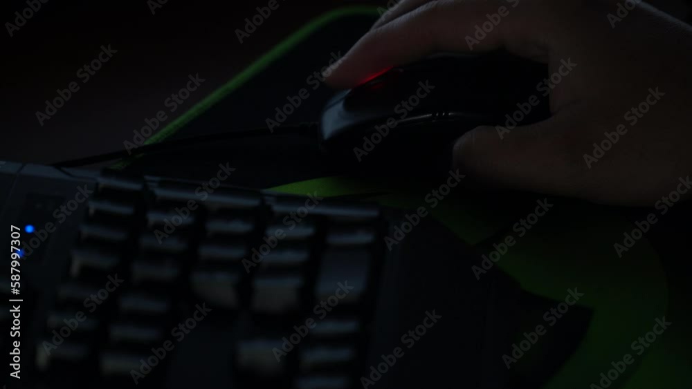 Wall mural a man browses a website with a mouse in front of a computer in a dark room