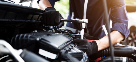 Fototapeta na wymiar Automobile mechanic repairman hands repairing a car engine automotive workshop with a wrench, car service and maintenance , Repair service