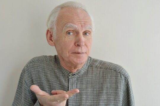 Facial portrait of an elderly gray-haired man with a joyful surprised look on a light background close-up
