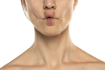 Close up of a woman over white background making fish face with lips, crazy and comical gesture. Funny expression.