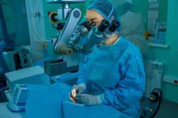 woman ophthalmologist performs an operation on the patient's eye