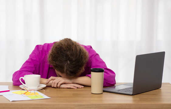 Overwork Concept. Exhausted female freelancer sleeping at desk in home office
