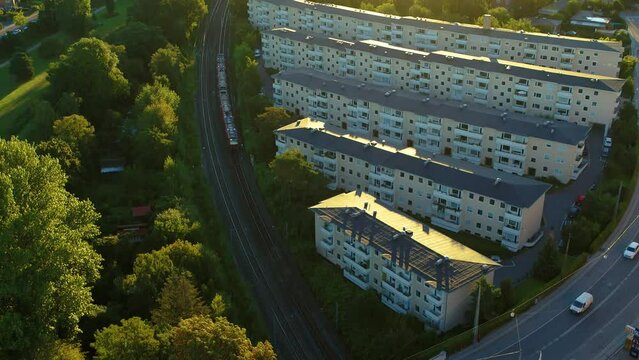 Drone hovering above train in Copenhagen. The camera follows the train driving through the suburbs of Copenhagen. Aerial 4K