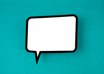 Naklejka premium The White speech bubble shaped post it note on green background with copy space.