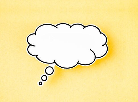 The White speech bubble shaped post it note on yellow background with copy space.