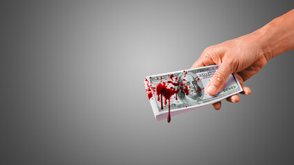 Hand giving bloody money. Splash blood on $100 Banknote. Money stained with blood. - obrazy, fototapety, plakaty