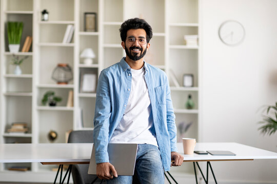 Portrait Of Handsome Indian Male Freelancer With Laptop Posing At Home