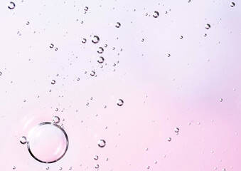 Facial serum oil surface with water bubbles. Abstract cosmetic liquid soft pink background for advertising and presentation of cosmetic products.