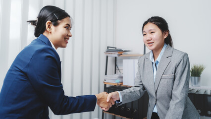 Shaking hands, Young Asia female leader business woman coaching new smes bookkeeping audit accounting interview with trainer training business job.