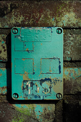 old green info sign on grungy wall.