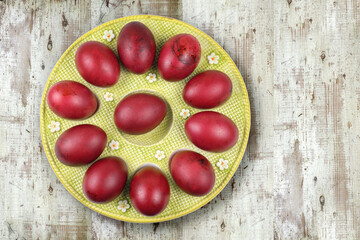 A plate of colored red Easter eggs on a wooden background