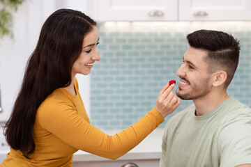Closeup of pretty woman feeding her handsome boyfriend