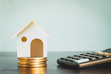 Home model put on the stack gold coin with growing value put on the desk in the office, Loan or...