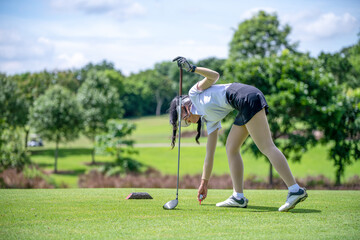 Professional woman golfer teeing golf in golf tournament competition at golf course for winner	