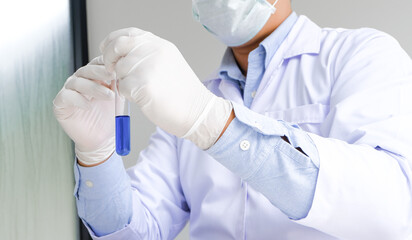 Science innovative Male medical or scientific laboratory researcher performs tests with blue liquid in laboratory. equipment science experiments technology Coronavirus Covid-19 vaccine research