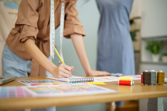 Tailor woman working in tailor shop Stylish Fashion designer tailor in workshop studio designing new collection Dressmaking and Creative.fashion collection.