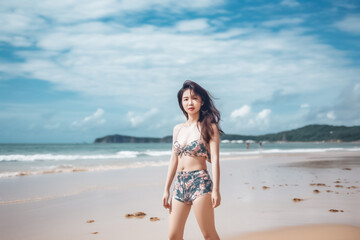 Fototapeta na wymiar young Asian woman in swimsuit is posting on the beach for photo shooting created with generative AI technology