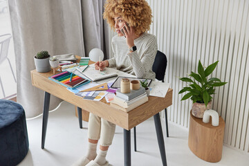 Busy woman interior designer works on design at workplace makes drawings of future apartment has...