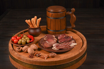 Dried Processed Beef Jerky with spices on a wood cut against dark background. Natural snack for beer. Organic food