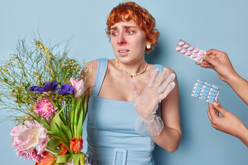 Unhappy redhead young lady suffers from flower allergy has red eyes and nose struggles with pollen...