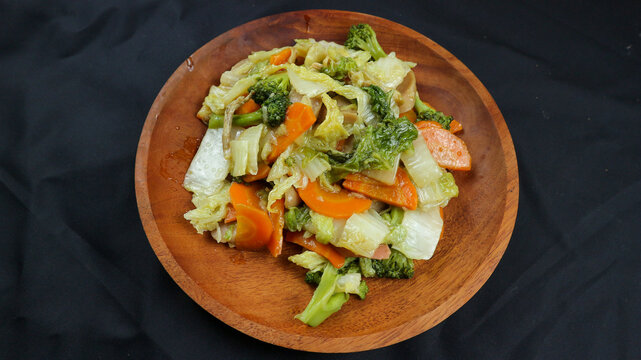 Fried capcay or cap cai or Hokkien is a mixture of vegetables stir-fried with chicken & other dishes. Isolated on black background.