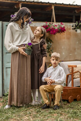 mom with two children, daughter and son are resting in the spring in the garden of a country house. concept of village life, love, mother's day