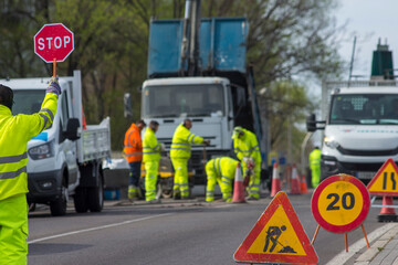 A group of construction workers are working on a road.