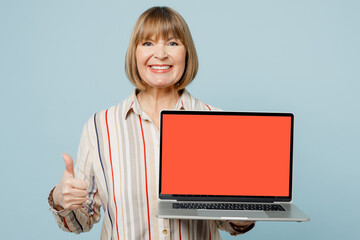 Elderly IT woman 50s years old wear light striped shirt hold use work on laptop pc computer with...