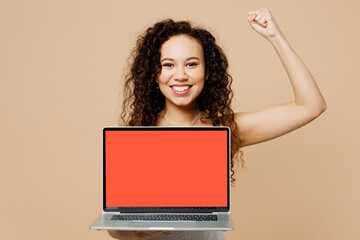 Happy young IT woman bride wear wedding dress posing hold use work blank screen workspace laptop pc computer do winner gesture isolated on plain beige background. Ceremony celebration party concept.