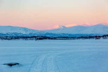 Foto op Canvas Abisko in Lapponia in Svezia. Tramonto al lago di Tornetrask ghiacciato. Sole, neve, ghiaccio, al circolo polare artico, un paesaggio del nord Europa © Claudio Quacquarelli