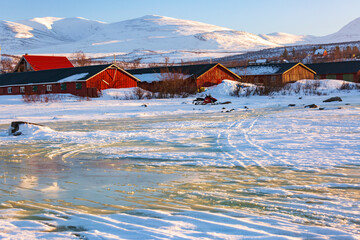 Abisko in Lapponia in Svezia. Tramonto al lago di Tornetrask ghiacciato. Sole, neve, ghiaccio, al circolo polare artico, un paesaggio del nord Europa