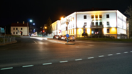 Obraz premium Night city light lines from cars. cars in highway with blur motion. Street view of the modern city at night. A lot of light from car headlights, advertising banners and night lights.