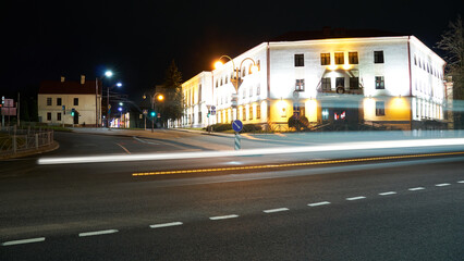 Fototapeta premium Night city light lines from cars. cars in highway with blur motion. Street view of the modern city at night. A lot of light from car headlights, advertising banners and night lights.