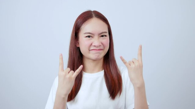 Asian woman showing rocker sign feeling enthusiastic