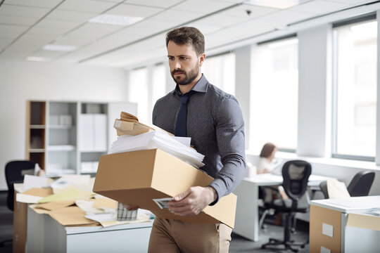 Handsome young businessman carrying a box out of office, Generative AI