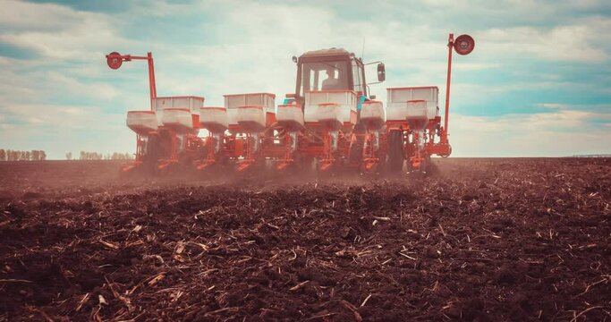 Agriculture. Tractor Seeder it Plants Seeds in the Ground in Field on the Farm. Slow motion. Tillage Equipment. 