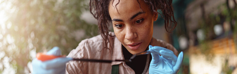 Woman florist making succulent plant composition at floral design studio and looking at camera
