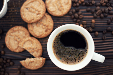Still life. Coffee in a white cup on a wooden table and cookies. Sweet backgrounds