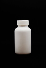 open white medicine bottle on the black background
