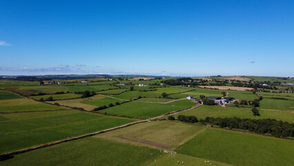 Fototapeta na wymiar Clear sky over the fields of southern Ireland. Picturesque summer landscape, sunny day. Green grass field under blue sky