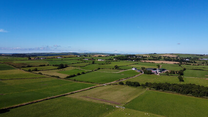 Naklejka premium Clear sky over the fields of southern Ireland. Picturesque summer landscape, sunny day. Green grass field under blue sky